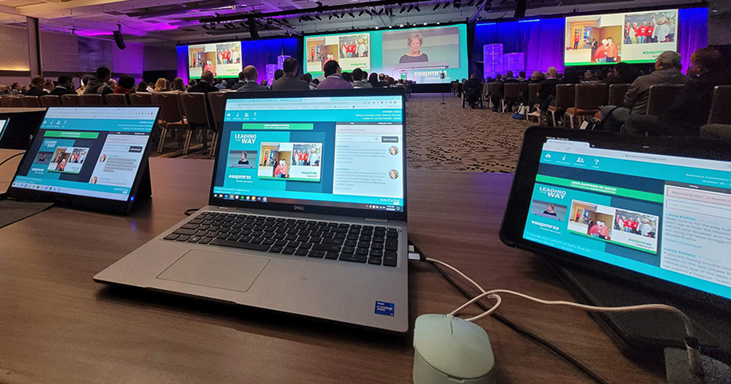 Image of several laptops set up at AAPM&R hybrid conference to capture live content for virtual participants. Maximizing virtual event impact.